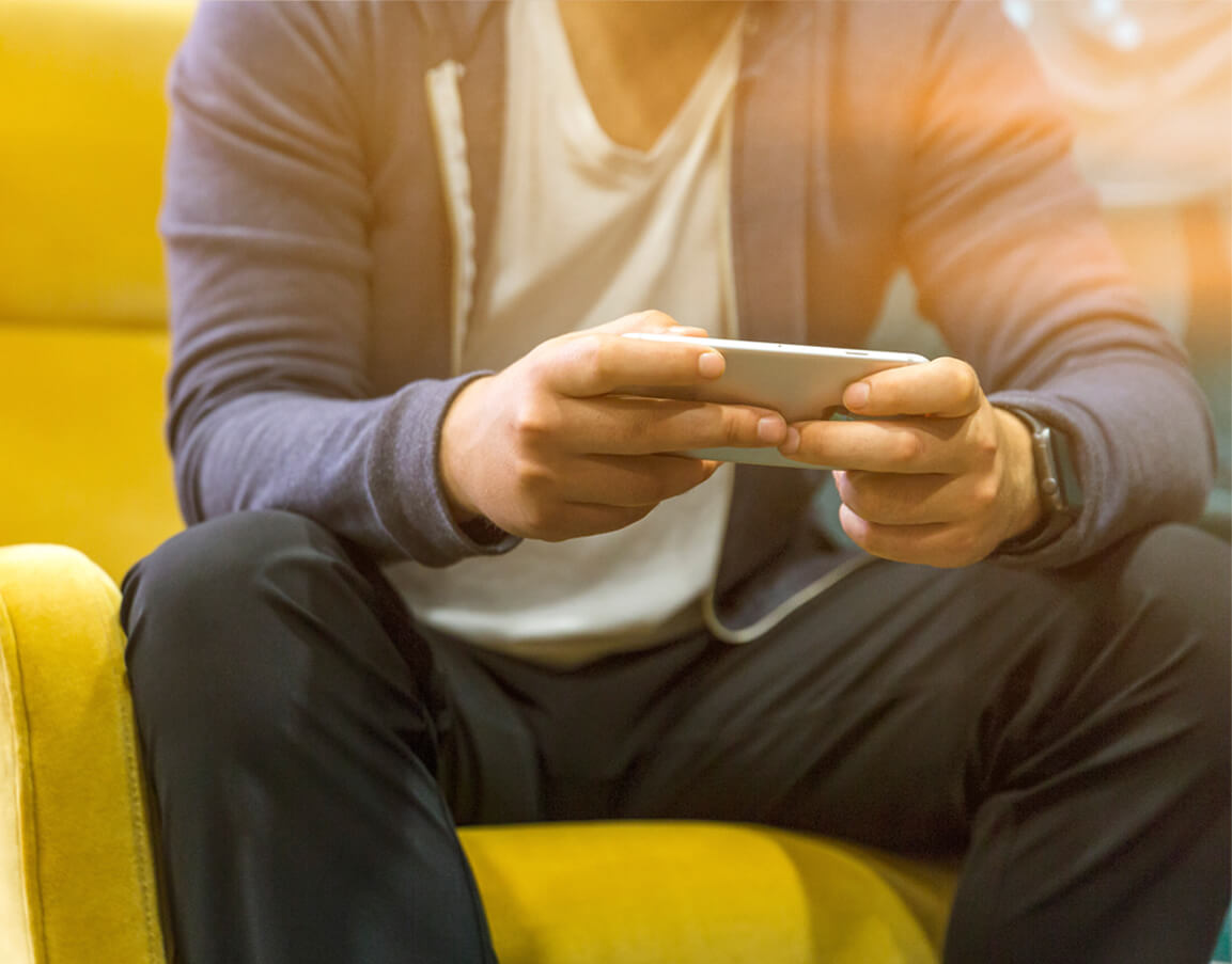 A man using his smartphone while sitting.